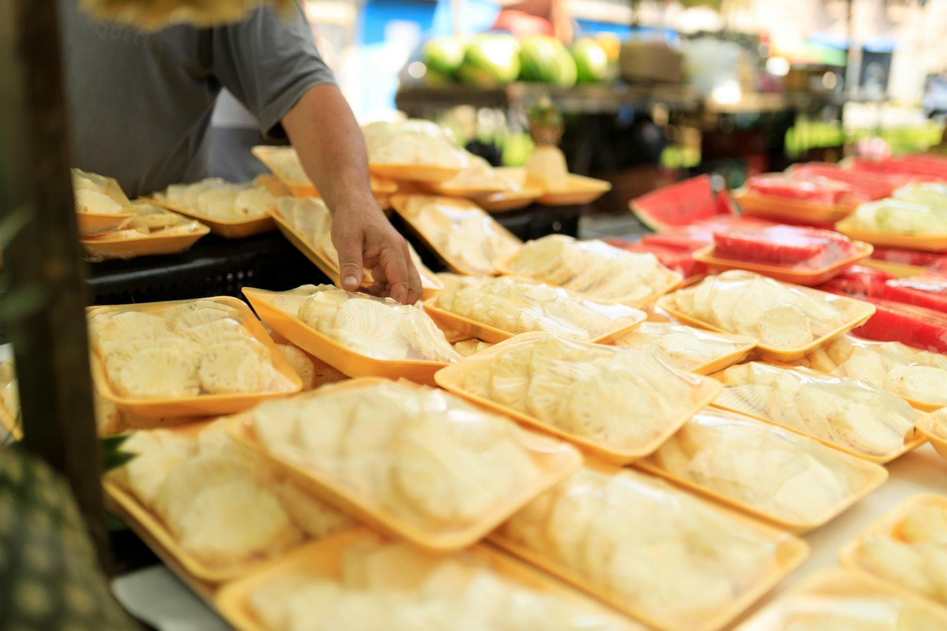 A person picking fresh packaged food at an outdoor market.