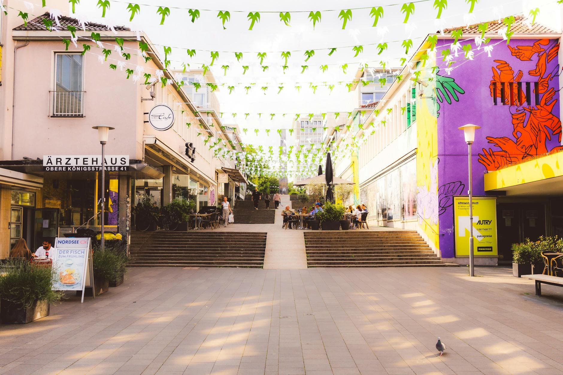 Vibrant street scene in Kassel, Germany with colorful buildings and hanging decorations.
