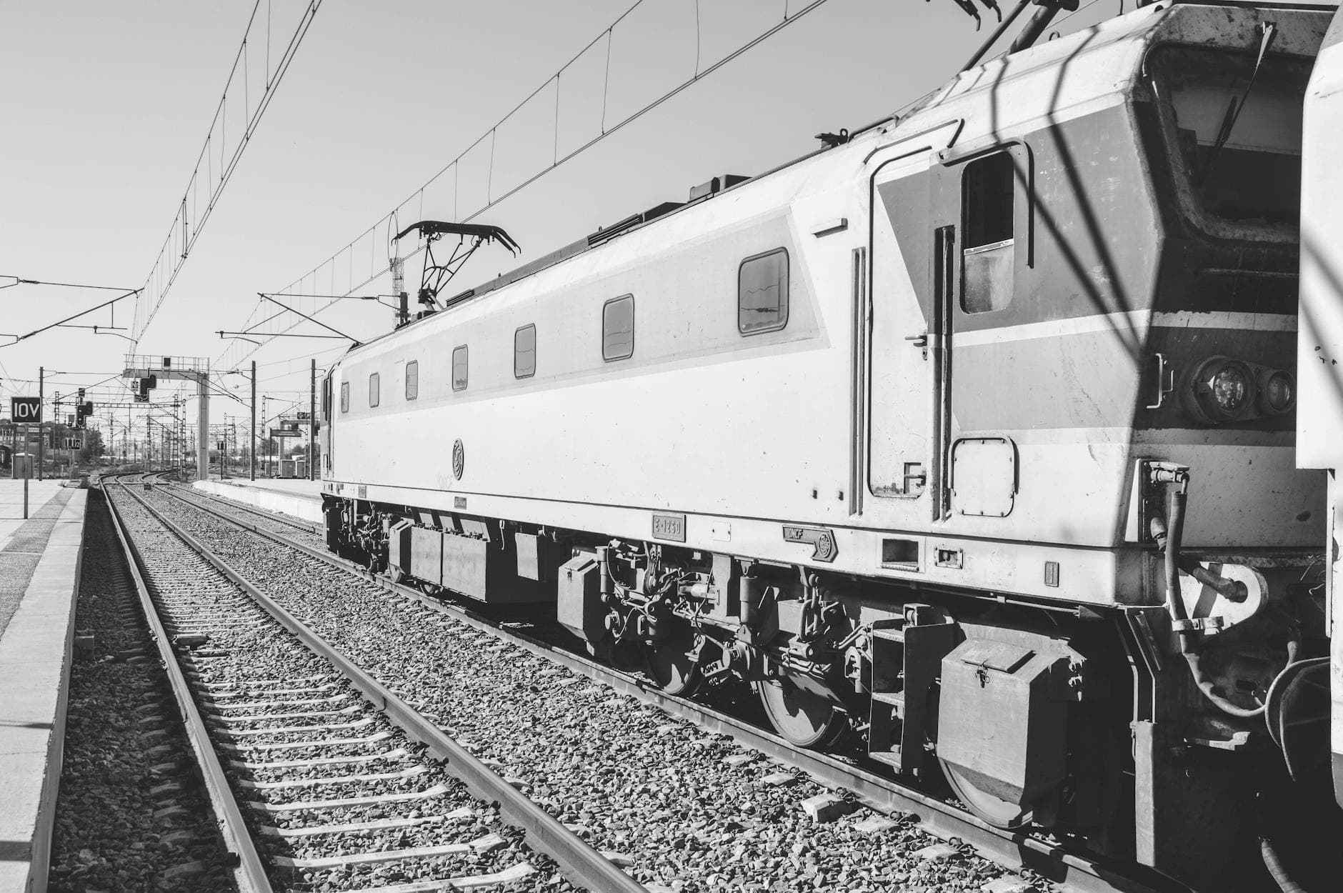 Vintage train in Kenitra, Morocco captured in grayscale, showing railway tracks.