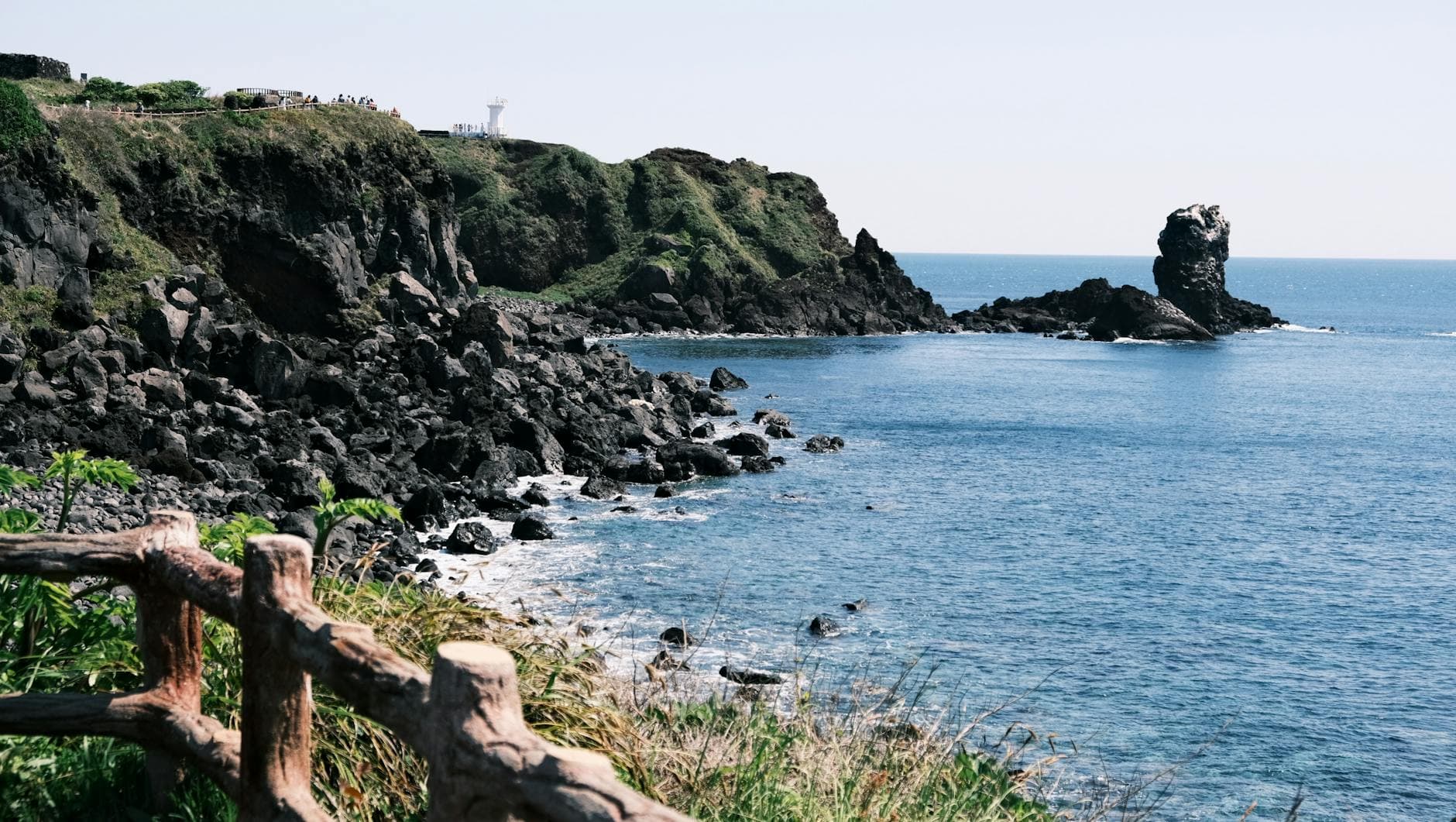 Breathtaking coastal landscape of Jeju Island, South Korea, featuring rocky cliffs and blue ocean.