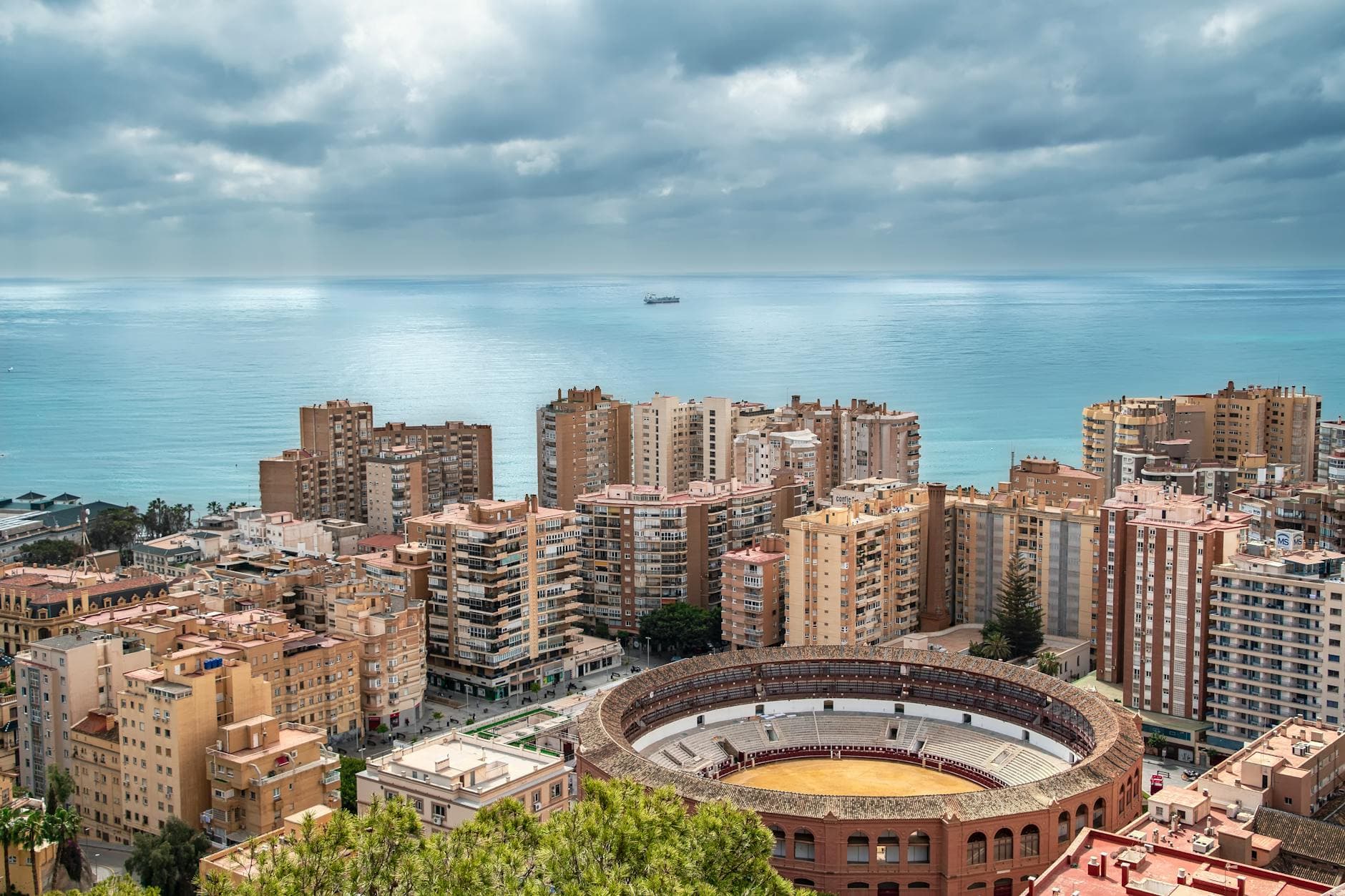 Aerial shot of Malaga's skyline featuring the bullring and sea horizon, perfect for travel themes.