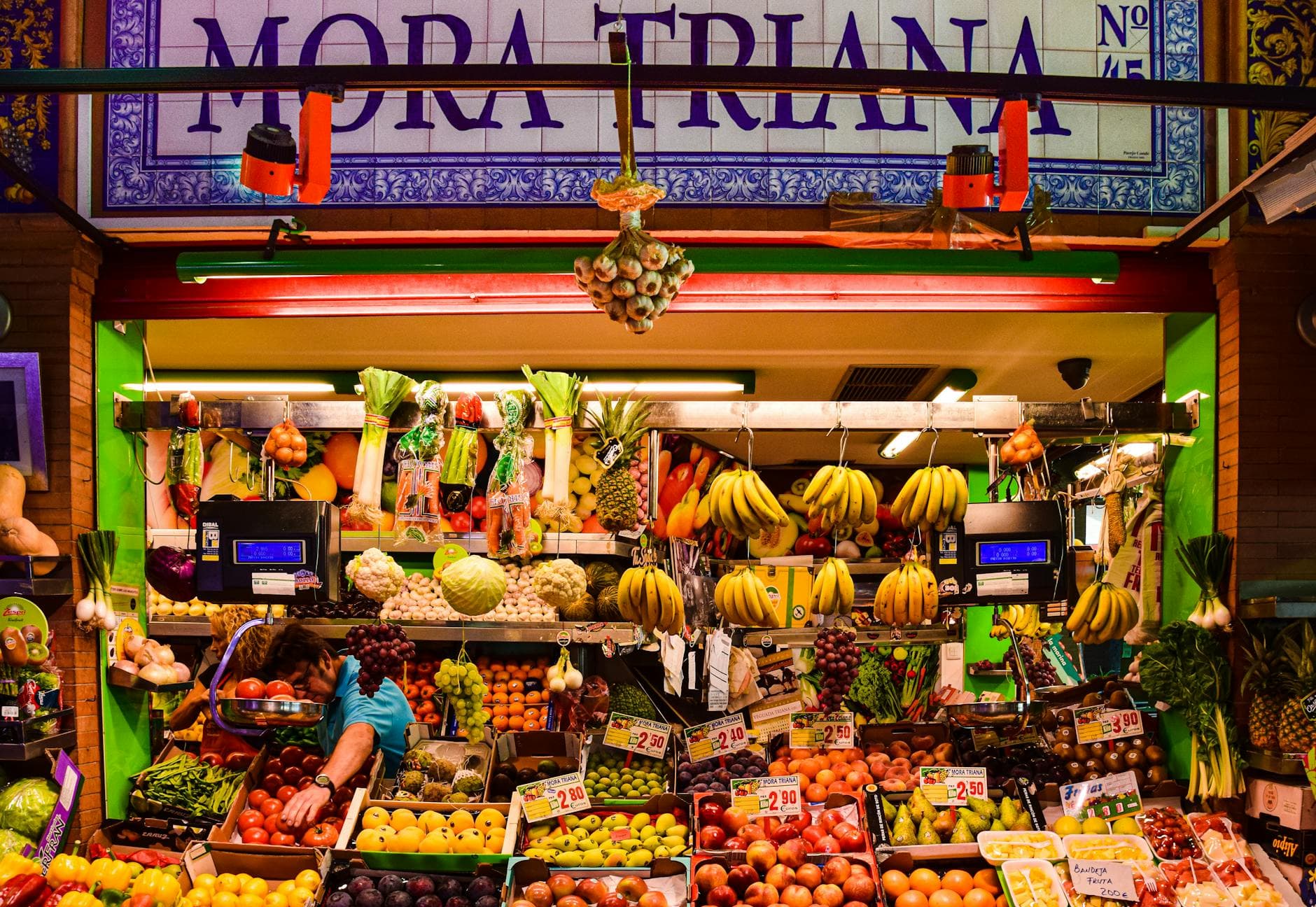 Colorful fruit stall in Triana Market, Seville, displaying a variety of fresh produce.