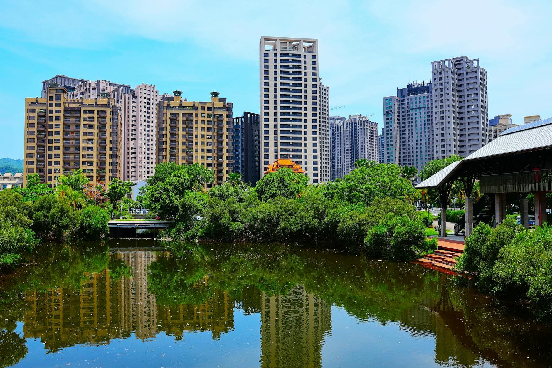 Stunning view of high-rise buildings reflecting in a pond in Kaohsiung City, Taiwan.