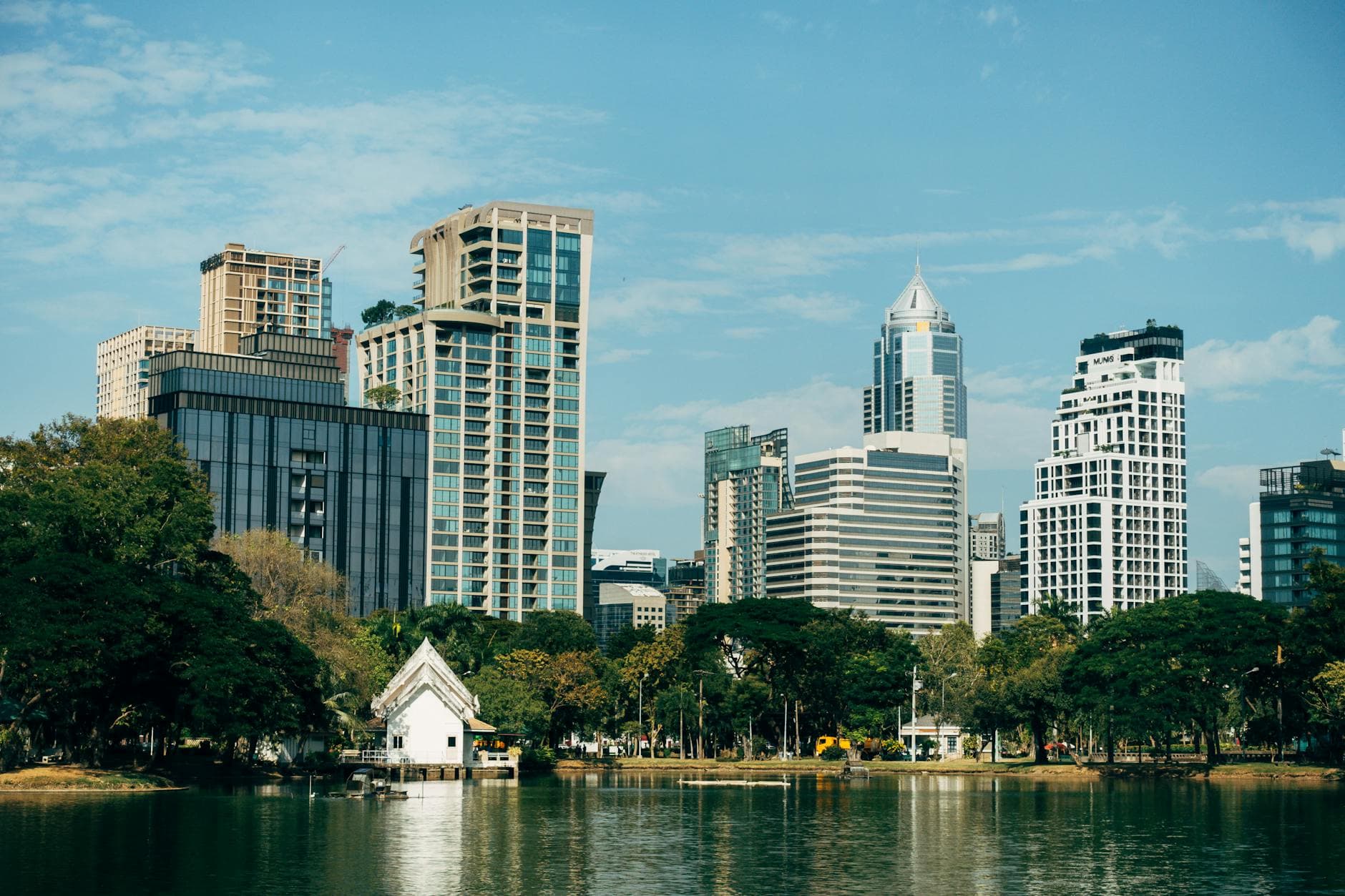 Stunning view of Bangkok's skyline with Lumphini Park and lake, showcasing nature and architecture.