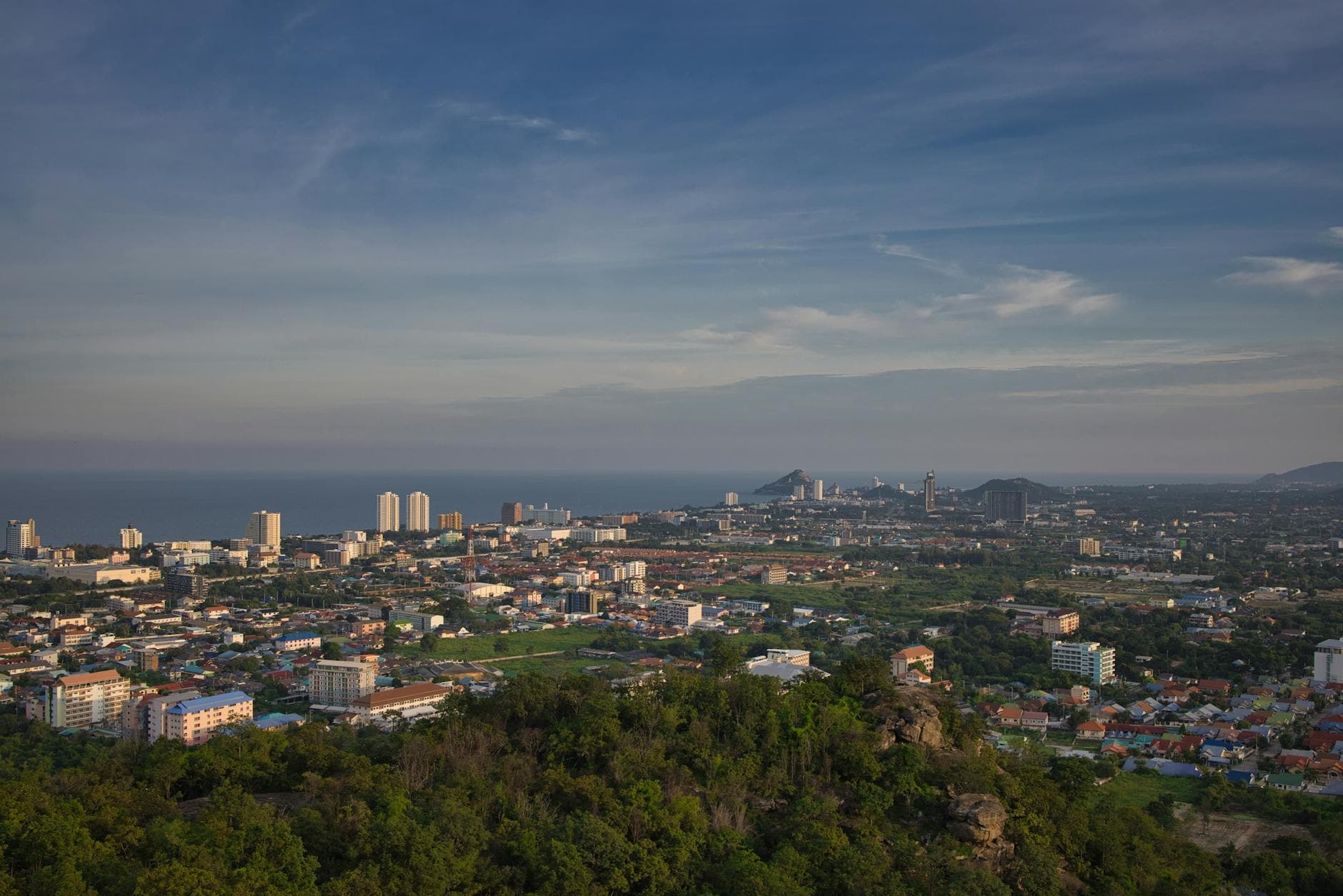 A stunning aerial view of Hua Hin with city buildings and ocean horizon.