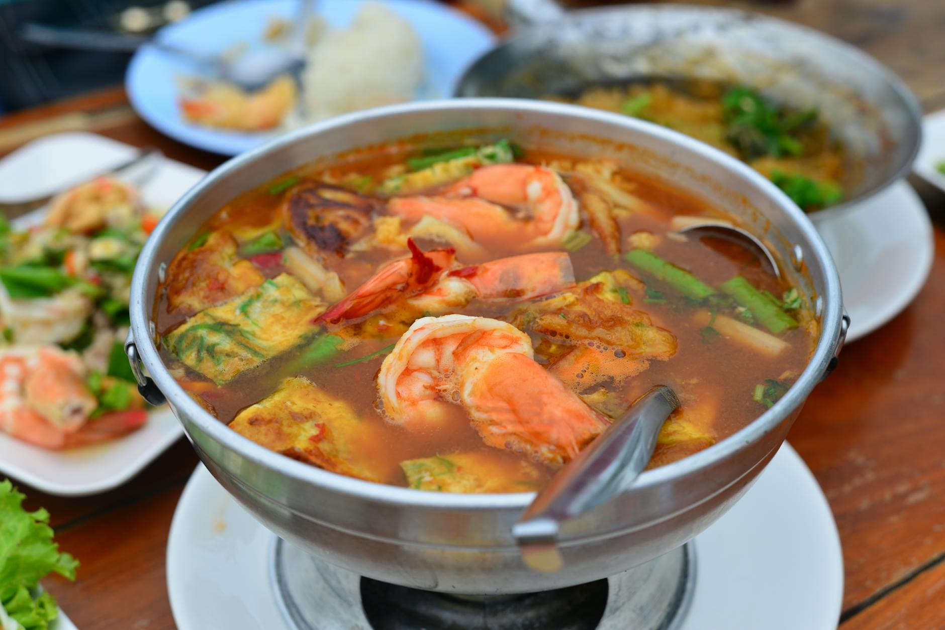 Close-up of a traditional Thai Tom Yum Goong soup with shrimp, known for its spicy flavors.