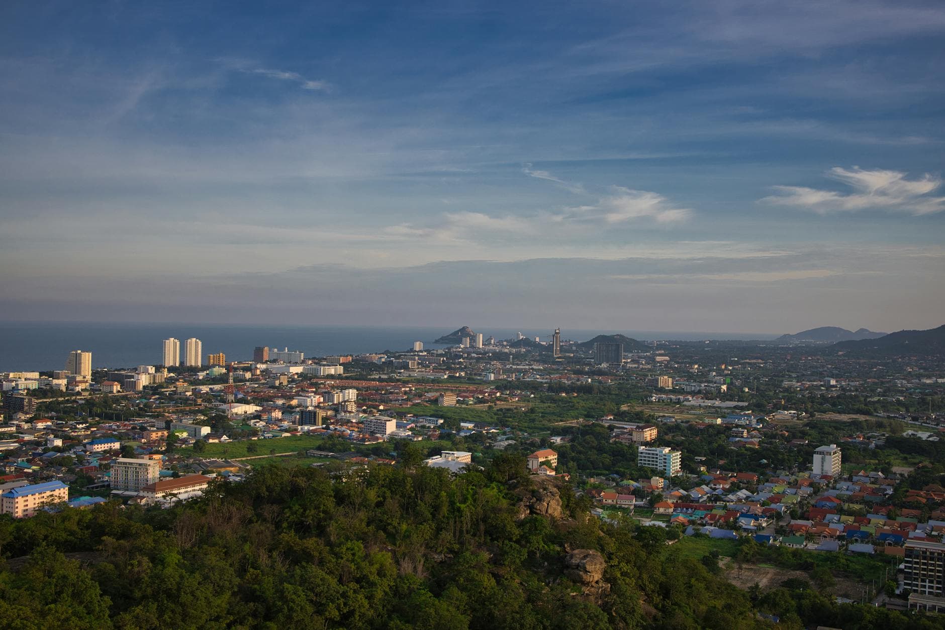 Panoramic aerial view of Hua Hin, Thailand with cityscape and ocean in the distance.