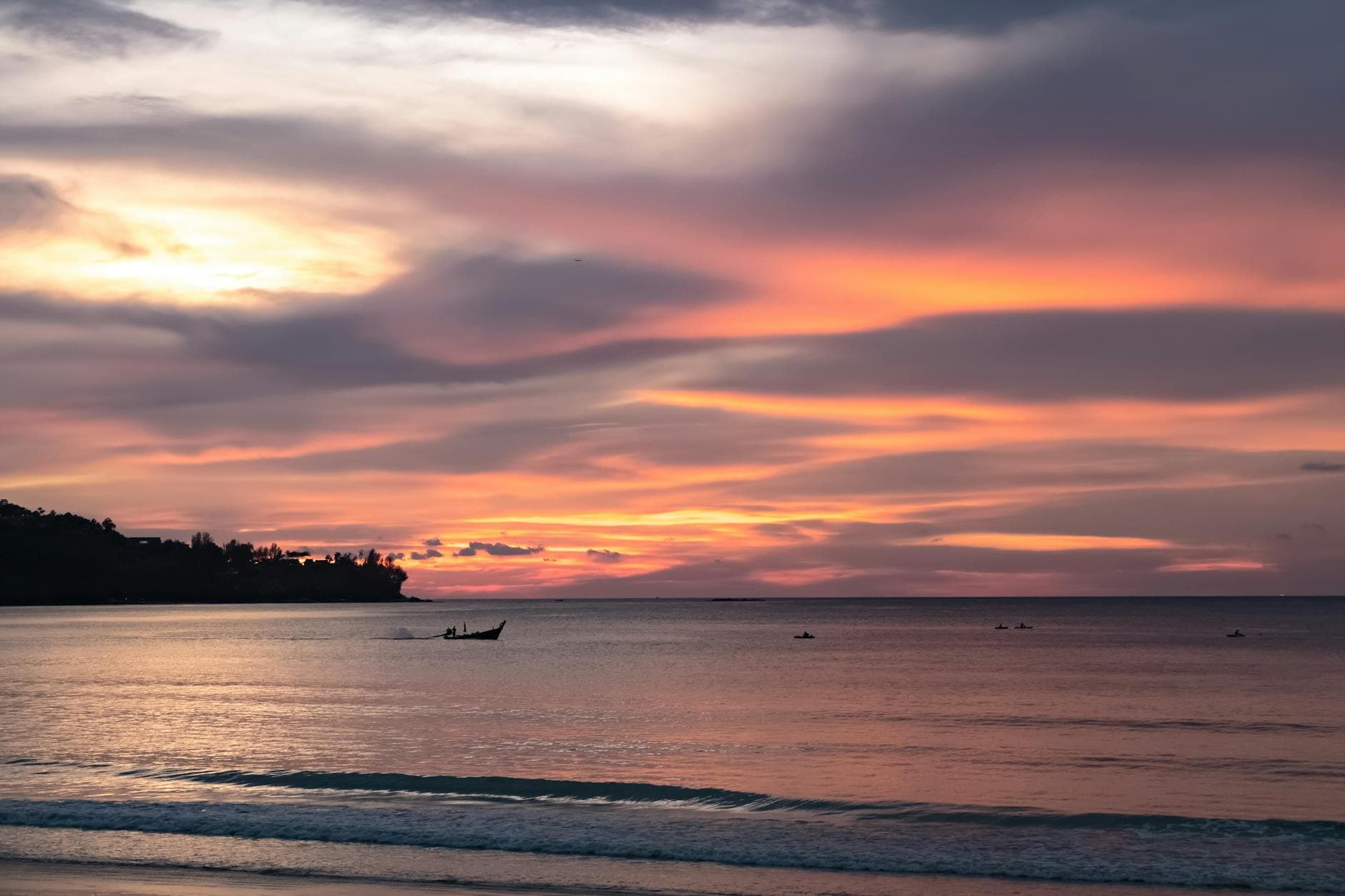 Beautiful sunset over the sea in Phuket, Thailand with colorful clouds and calm water.