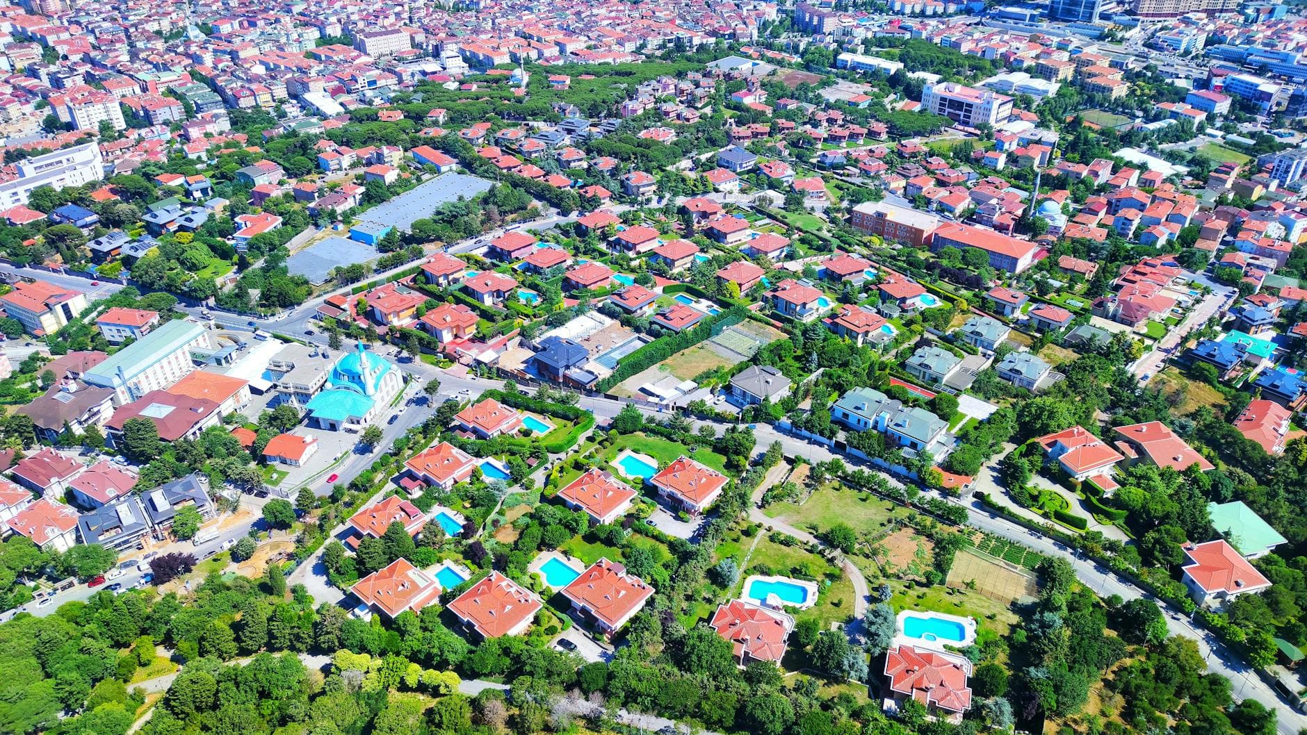 Aerial photo of a suburban area in Istanbul showcasing houses, greenery, and vibrant rooftops.