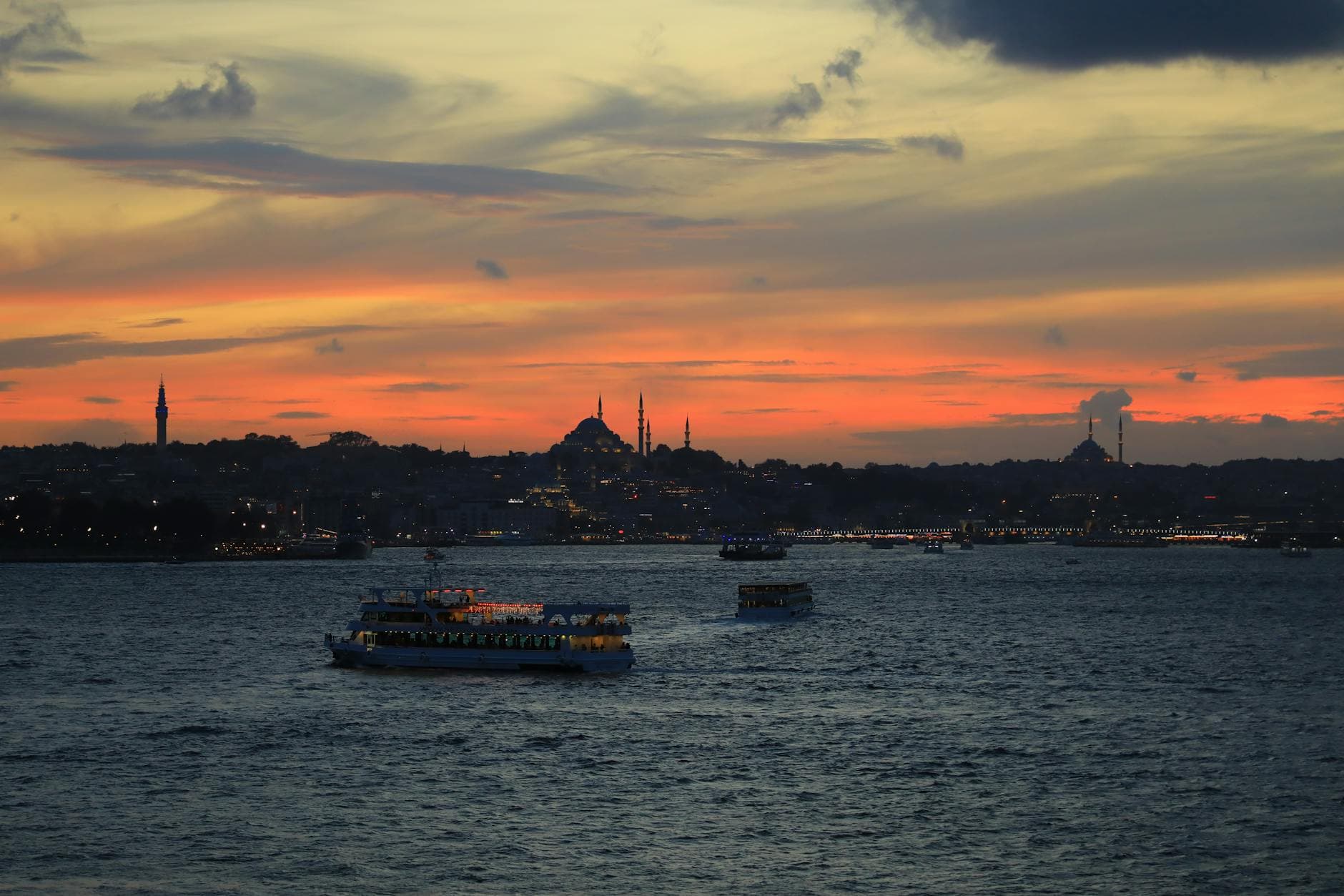 Beautiful sunset view of the Bosphorus with boats and İstanbul skyline.