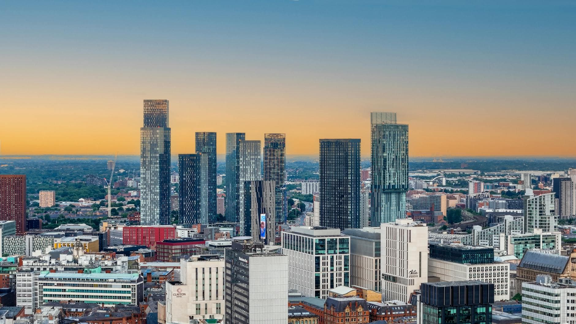A stunning sunset view of modern skyscrapers in Manchester's bustling city center.