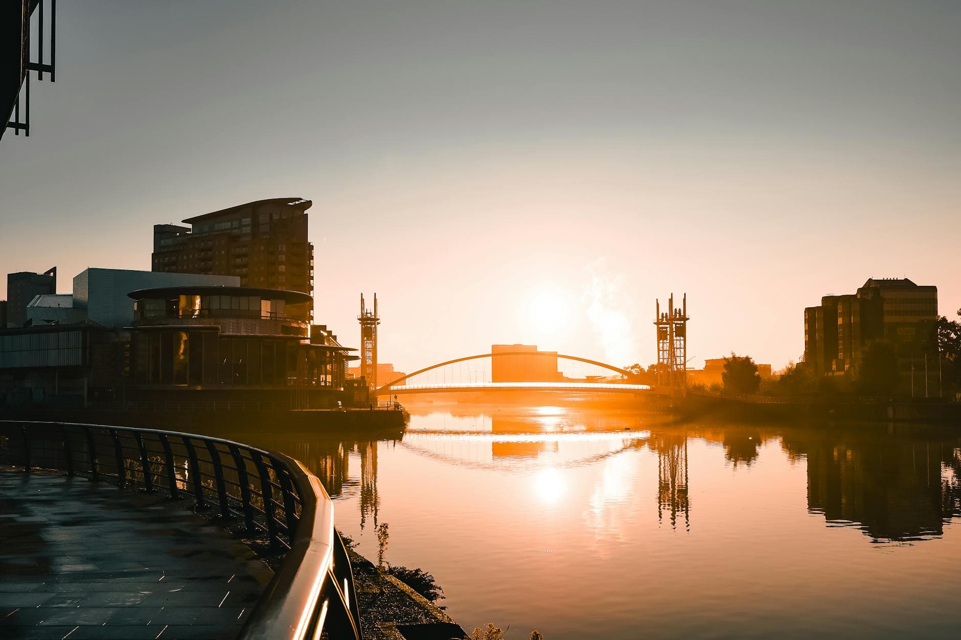 Sunrise illuminating Salford Quays with stunning reflections and urban architecture.