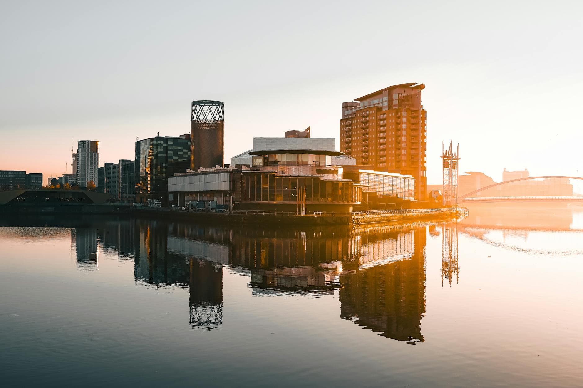 Captivating sunset view of Salford Quays with beautiful reflections on water. Iconic urban architecture in warm light.