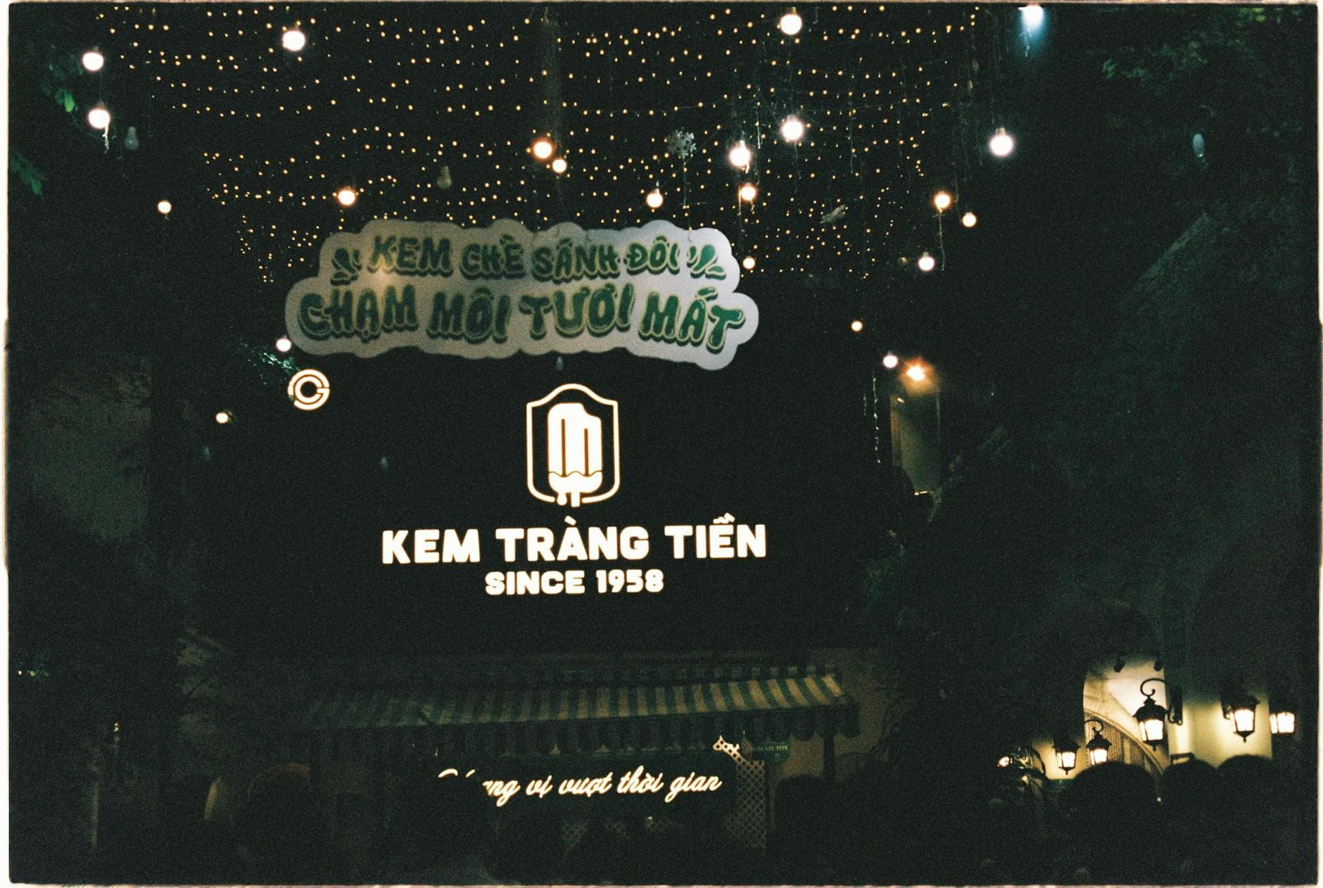 Beautiful night scene in Hanoi showcasing Kem Tràng Tiền ice cream shop decorated with lights.