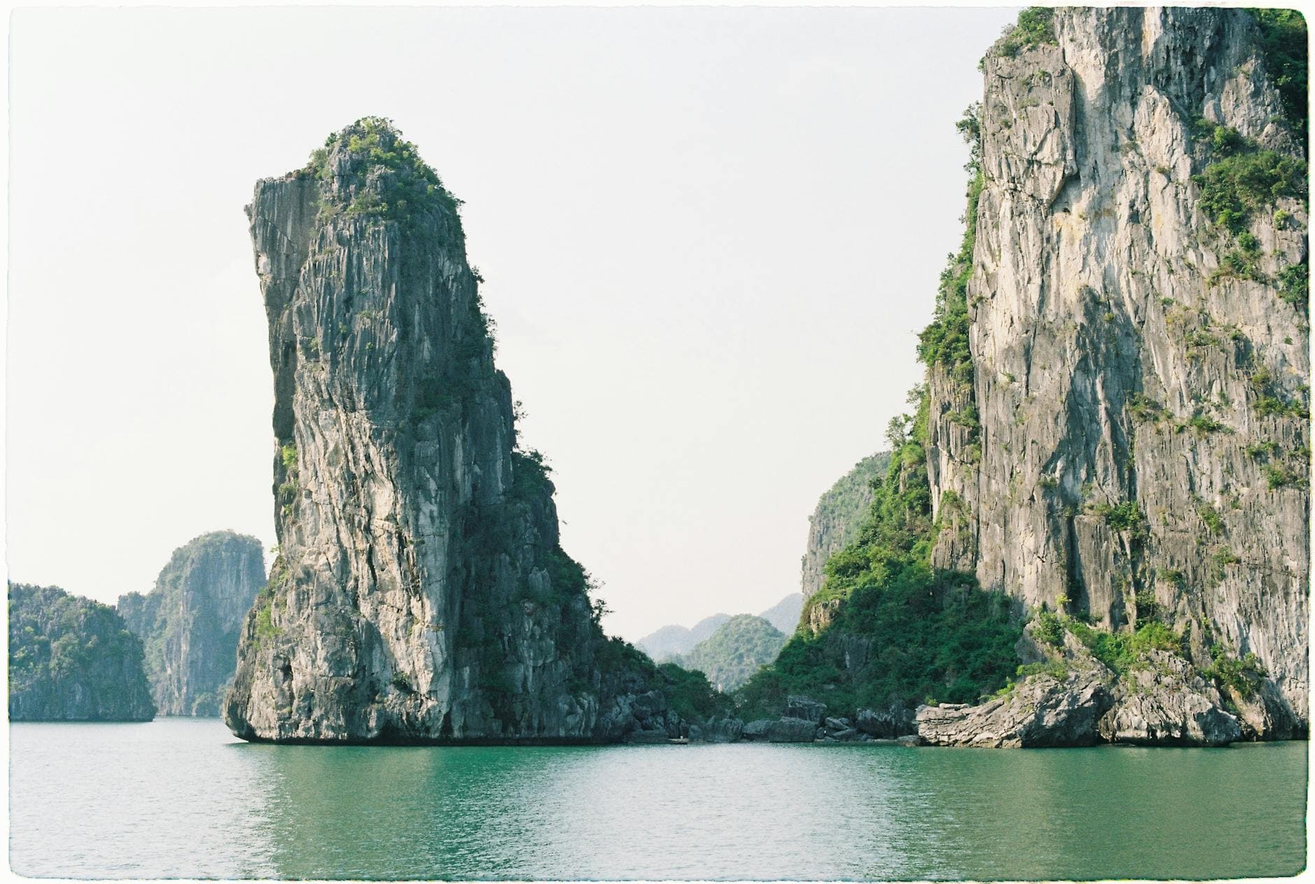 Scenic view of towering limestone islands in Ha Long Bay, Vietnam, under clear skies.